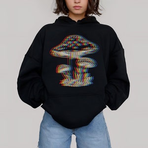 May include: A black hoodie with a rainbow-colored mushroom graphic. The mushroom has a large cap and a stem with two smaller mushrooms growing from it. The hoodie has a drawstring hood and a kangaroo pocket.