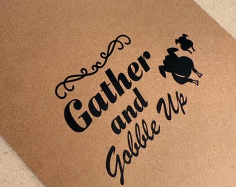 以下が含まれることがあります： 「Gather and Gobble Up」の黒い筆記体で書かれた、茶色のタグ型のサイン。2つの黒い七面鳥のシルエットが右側にあります。吊り下げ用の天然麻ひもループが上部にあります。