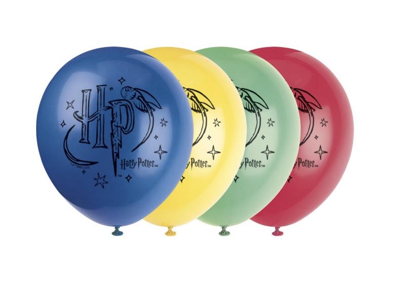 May include: Four round balloons in blue, yellow, green, and red. Each balloon has a black graphic of the Harry Potter logo and text. The balloons are inflated, ideal for a party or celebration.