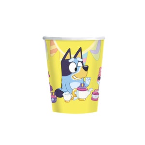 May include: A set of 8 yellow paper cups featuring Bluey and Bingo from the cartoon show Bluey. The cups have a colorful party theme with streamers and a tea party scene.