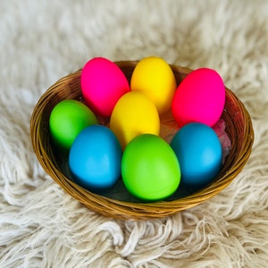 May include: A wicker basket filled with colorful Easter eggs. The eggs are painted in shades of pink, yellow, green, and blue.