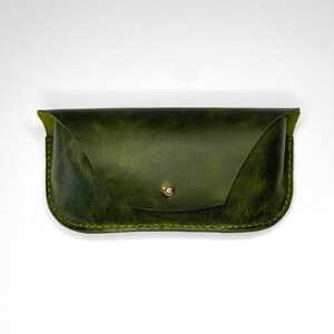 May include: A green leather glasses case with a gold button closure.