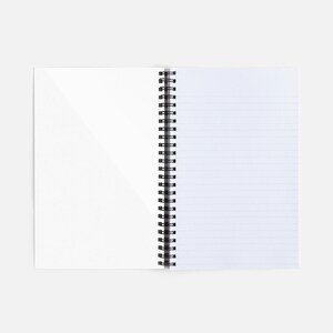 Op de afbeelding: Een open spiraalnotitieblok met wit, gestreept papier. Het notitieblok ligt plat op een wit oppervlak.