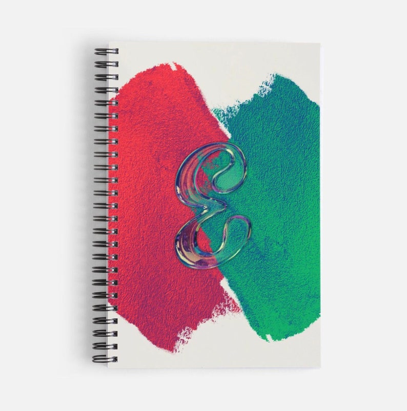 Op de afbeelding: Een spiraalgebonden notitieboek met een witte omslag met een abstract rood en groen verfdesign. De letter "e" bevindt zich in het midden van het ontwerp, met een holografische afwerking.