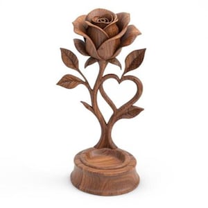 Può includere: Scultura di rosa in legno intagliato. La scultura presenta un fiore di rosa dettagliato, foglie e un design a forma di cuore. La rosa poggia su una base rotonda. Il legno ha una finitura naturale e calda. Altezza: circa 15 cm.