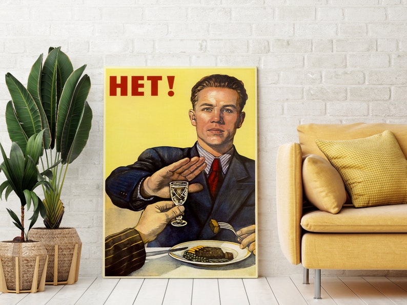 May include: A vintage propaganda poster with a man in a suit saying "HET!" while holding up his hand to stop someone from drinking a glass of alcohol. The poster has a yellow background with red text.