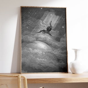 May include: A black and white framed print of a winged figure falling from the sky, surrounded by clouds and stars. The print is set against a white wall and a wooden desk.