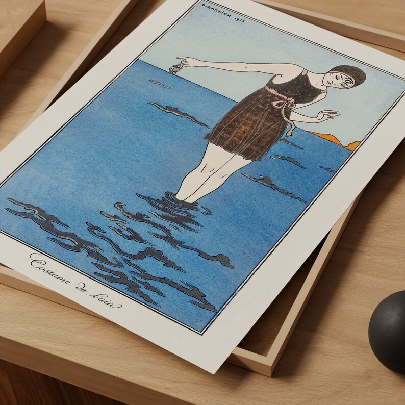 May include: A vintage illustration of a woman in a dark brown swimsuit standing in the ocean. The water is blue and the sky is a light orange. The text "Costume de Bain" is written at the bottom of the image.