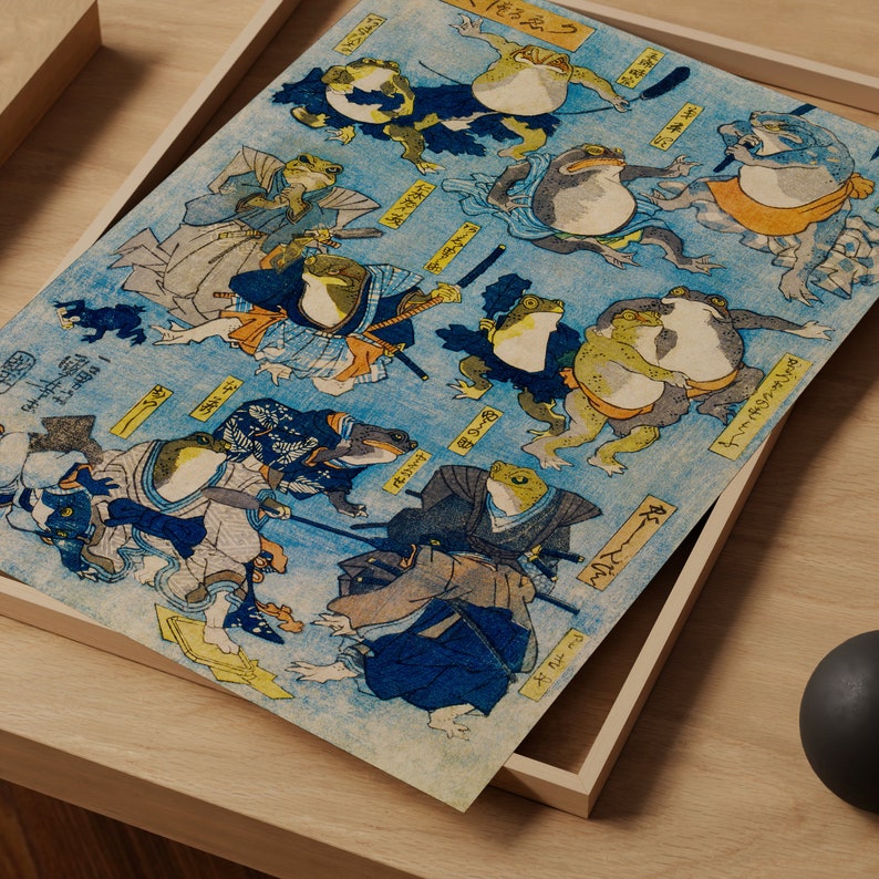 May include: A vintage Japanese woodblock print depicting frogs dressed as samurai warriors. The print features intricate details and vibrant colors, including blue, green, red, and yellow. The frogs are depicted in various poses, holding swords and other weapons. The print is titled "Frog Samurai" in Japanese characters.