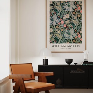 May include: A framed poster featuring a floral pattern in shades of green, blue, pink, and white. The poster is titled "William Morris" with the text "Golden Lily | 1880" below the title.