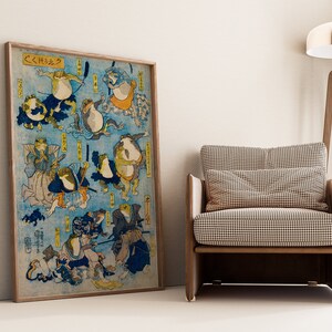 May include: A vintage Japanese woodblock print depicting a group of frogs in various poses, some wearing traditional clothing, against a blue background. The print is framed and titled "くくしゅう".