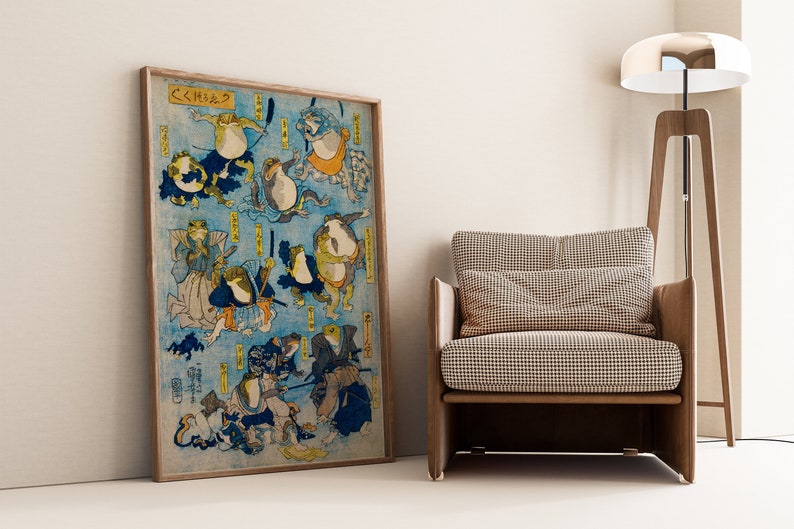 May include: A vintage Japanese woodblock print depicting a group of frogs in various poses, some wearing traditional clothing, against a blue background. The print is framed and titled "くくしゅう".