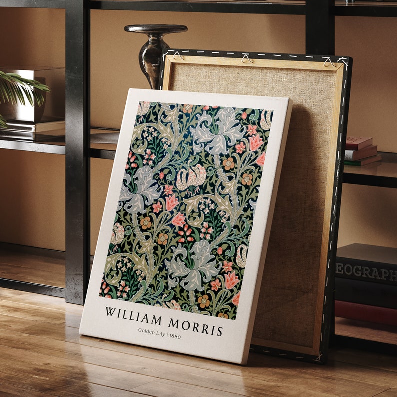 May include: A white canvas print featuring a floral pattern in shades of green, pink, and blue. The print depicts a stylised design of lilies and leaves. The text "William Morris" and "Golden Lily | 1880" is printed at the bottom of the canvas.