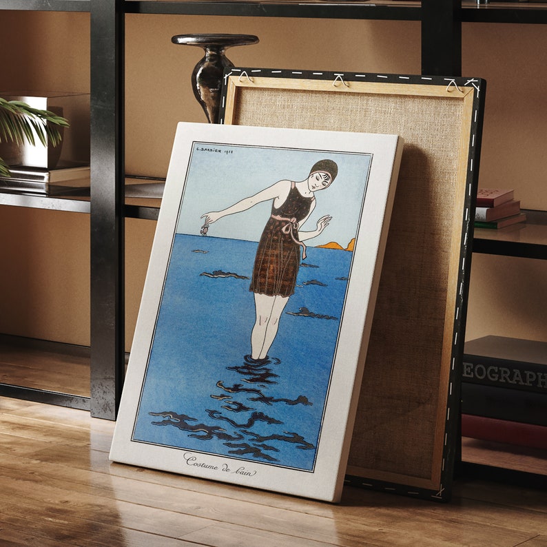 May include: A vintage illustration of a woman in a swimsuit standing in the ocean. The woman is wearing a black and white striped swimsuit with a pink sash. The ocean is blue and there are waves in the background. The text "Costume de Bain" is printed at the bottom of the image.