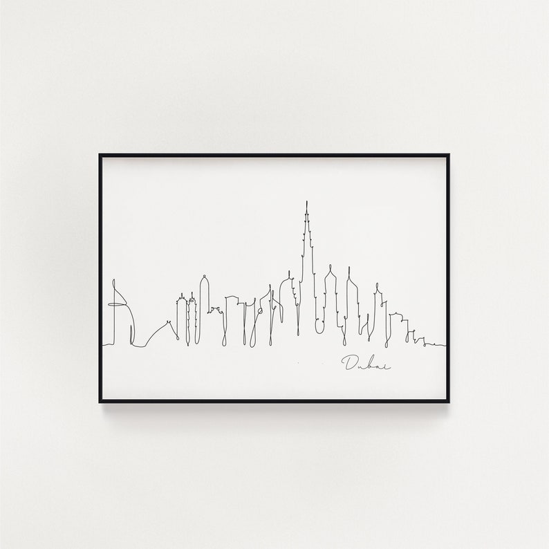 May include: A black and white line drawing of the Dubai skyline, including the Burj Khalifa. The drawing is framed in a black frame and the word "Dubai" is written below the skyline.