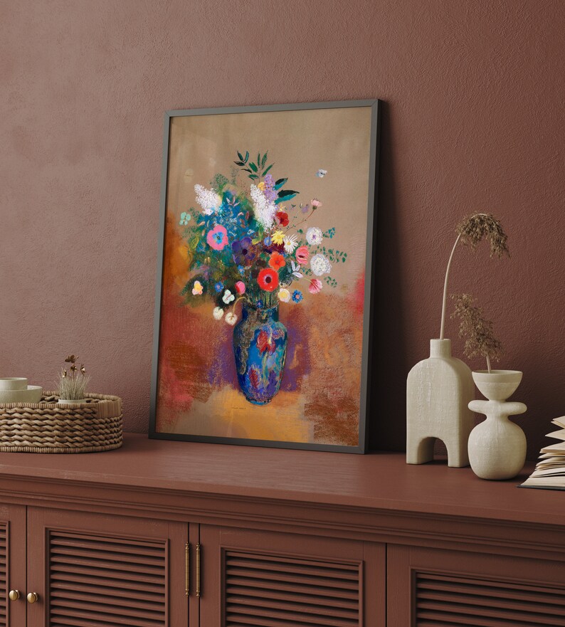 May include: A framed floral art print featuring a vibrant bouquet in a blue vase. The artwork showcases colorful flowers in shades of red, pink, blue, and white, set against a textured background. The frame is black.