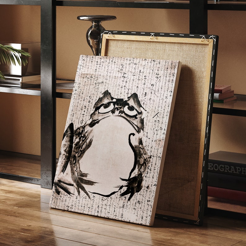 May include: A black and white illustration of a frog on a canvas print. The print is framed and has a white background with black text.