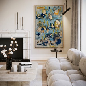 May include: A white and gray sectional sofa with a black side table in front of it. A framed print of a Japanese woodblock print depicting frogs in various poses hangs on the wall above the table. The print is in shades of blue, yellow, and red. The text on the print reads "くくはつ".