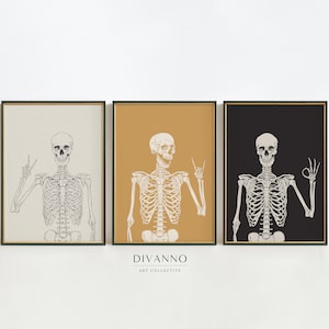 Puede incluir: Tres impresiones enmarcadas de un esqueleto con un signo de paz. Las impresiones están sobre fondos beige, amarillo mostaza y negro. El texto "DIVANNO ART COLLECTIVE" está debajo de las impresiones.