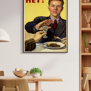 May include: A vintage propaganda poster with a man in a suit and tie saying "HET!" while holding up his hand to refuse a glass of alcohol and a plate of food.