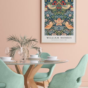 Op de afbeelding: Een ingelijste print van een vintage bloemenontwerp met vogels en bessen. De print is getiteld "William Morris, The Strawberry Thief, 1883".