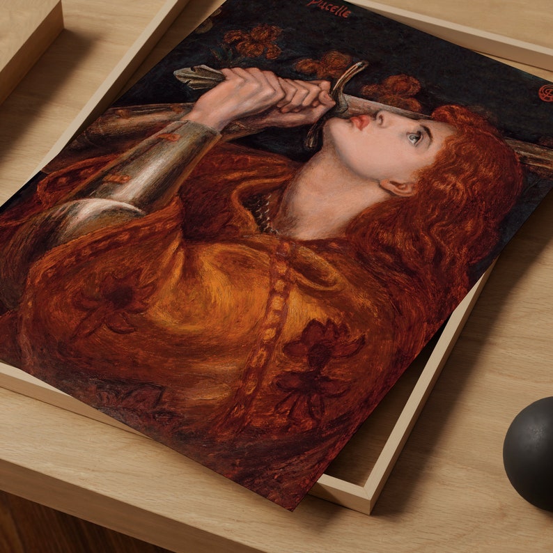May include: A painting of a woman in a golden robe holding a sword. Her red hair flows down her back and she looks up with a determined expression. The painting is titled "La Pucelle" in the upper right corner.