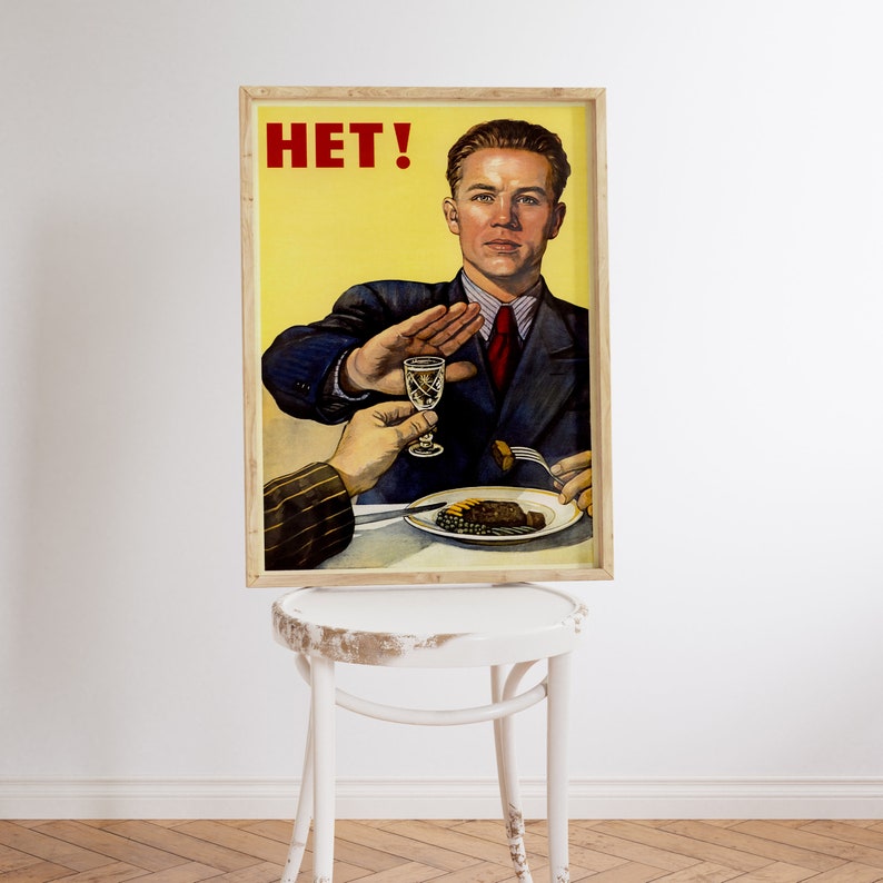 May include: A vintage Soviet-style propaganda poster with a man in a suit saying "HET!" while holding up his hand to refuse a glass of alcohol. The poster has a yellow background and is framed in wood.