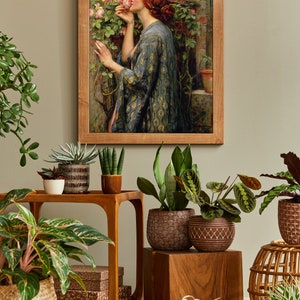 Op de afbeelding: Een ingelijst schilderij van een vrouw in een blauwe en gouden jurk die aan een roze roos ruikt in een tuin. Het schilderij is omringd door planten in potten, waaronder een slangplant, een succulent en een spinplant.
