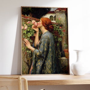 Op de afbeelding: Een schilderij van een vrouw in een blauwe en gouden gebloemde jurk, die aan een roze rozenstruik ruikt. De vrouw heeft rood haar en staat in een tuin.