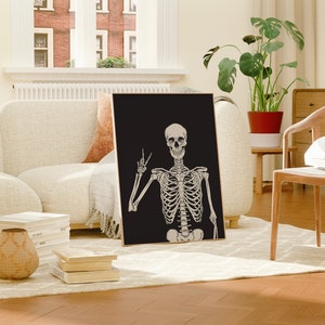 May include: A black and white poster featuring a skeleton giving the peace sign. The skeleton is on a black background.