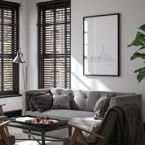 May include: A living room interior with a gray sofa, two chairs, a coffee table, and a framed print of the Dubai skyline. The room has wood blinds on the windows and a lamp on the floor.