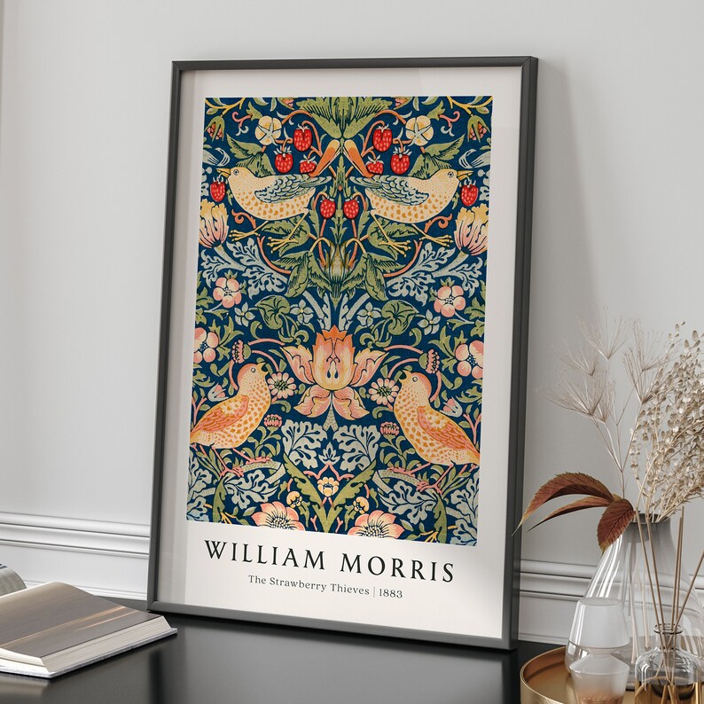 Op de afbeelding: Een ingelijste print van een vintage bloemenpatroon met vogels en bessen. De print is getiteld "William Morris, The Strawberry Thieves, 1883".