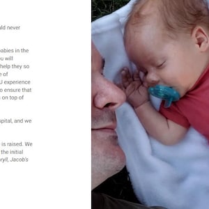 May include: A sleeping baby wearing a red onesie with a graphic of a tent and trees. The baby is lying on a white blanket with a blue pacifier in their mouth. A person's face is visible in the image.