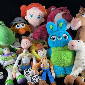 May include: A collection of plush toys featuring characters from the Toy Story franchise. The toys include Woody, Buzz Lightyear, Jessie, Rex, Lotso, Mr. Potato Head, and others. The toys are brightly colored and made of soft materials.