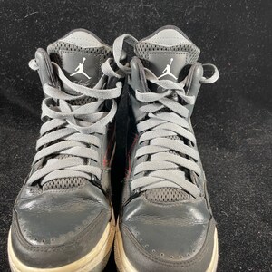 May include: A pair of black and gray high-top sneakers with gray laces and a white Jumpman logo on the side.