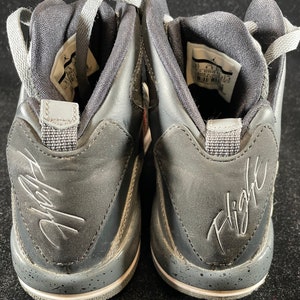 May include: A pair of black leather high-top sneakers with a white sole and gray accents. The sneakers have a signature "Flight" inscription on the back.