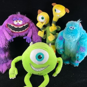 Puede incluir: Colección de peluches con personajes de la película de animación Monstruos, S.A. Los juguetes incluyen un gran monstruo morado, un cíclope verde, un monstruo azul con manchas moradas y dos monstruos amarillos. Los juguetes son suaves y coloridos.
