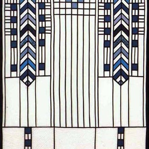 Op de afbeelding: Een glas-in-loodraam met een geometrisch ontwerp met zwarte lijnen en blauwe en witte glaspanelen. Het ontwerp omvat een reeks verticale lijnen en twee sets chevronpatronen.
