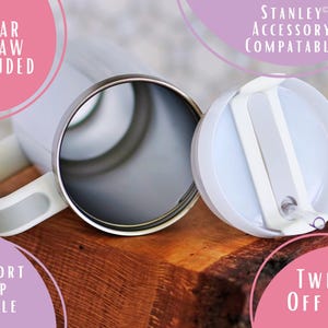May include: A white insulated tumbler with a silver rim and a white handle. The tumbler includes a clear straw and a twist-off lid. The handle is a comfort grip. The text on the image says "Stanley Accessory Compatable".