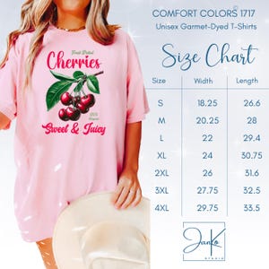May include: Pink unisex t-shirt with a graphic of cherries and the text "Fresh Picked Cherries 100% Organic Sweet & Juicy". Size chart with measurements in inches.