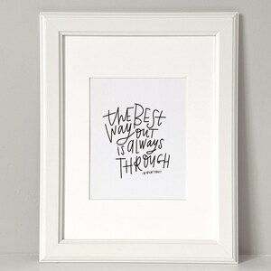 Puede incluir: Una impresi&oacute;n enmarcada en blanco con caligraf&iacute;a negra que dice "The best way out is always through" con el nombre del autor "Robert Frost" debajo.