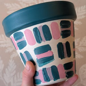 May include: A set of three ceramic mugs with a speckled, matte finish. The mugs are in shades of cream, light gray, and dark gray. Each mug has a simple, minimalist design, perfect for coffee or tea.