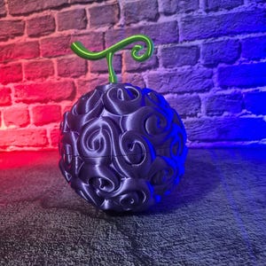 May include: A dark purple, spherical object with a green stem. The surface of the sphere is covered in swirling, textured patterns. The object is set against a brick wall with red and blue lighting.