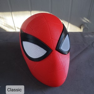 May include: A red and black Spider-Man mask with a textured surface and white mesh eye holes. The mask is labeled "Classic".