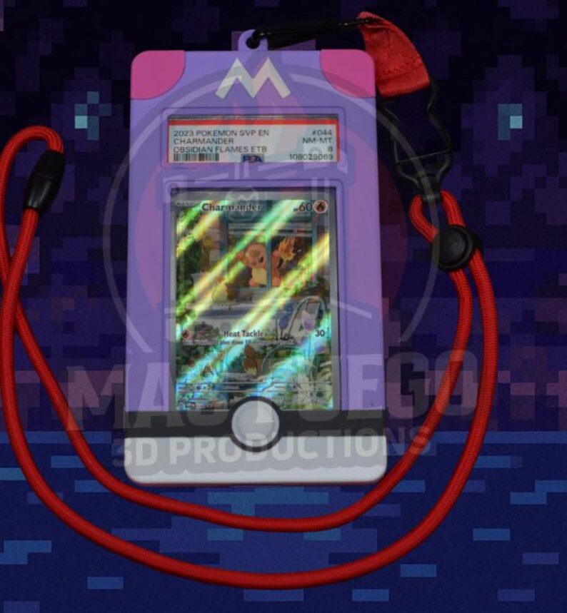 May include: A purple card holder with a red lanyard, displaying a Pok&eacute;mon trading card. The card features a Charmander illustration and text. The holder has a white button and the text "MA FGO 3D PRODUCTIONS".