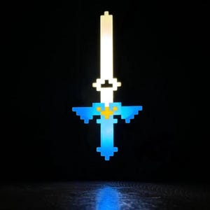 May include: Pixelated sword with a white blade and blue hilt, accented with yellow. The sword is illuminated against a black background, creating a glowing effect. The design is reminiscent of a video game aesthetic.