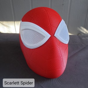 May include: A red and white Spider-Man mask with a textured surface. The mask has a white mesh over the eyes.