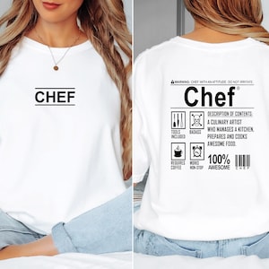 May include: White t-shirt with the word "CHEF" printed on the front and a label on the back that reads "Chef" with a description of contents: "A culinary artist who manages a kitchen, prepares and cooks awesome food."  The label also includes icons for tools, badass, coffee, and non-stop work.