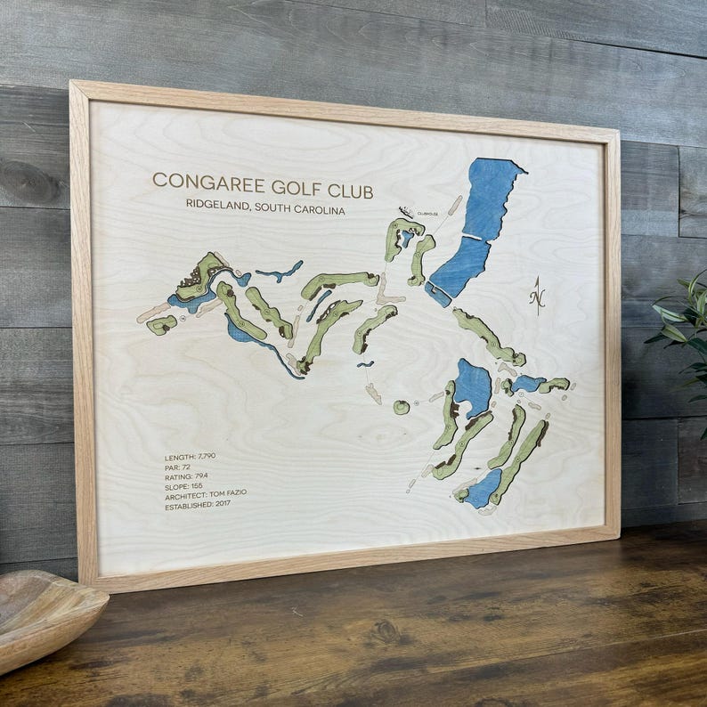 May include: A framed wooden map of the Congaree Golf Club in Ridgeland, South Carolina. The map features light wood grain, green fairways, and blue water hazards. Text includes course details like length, par, rating, slope, and architect.