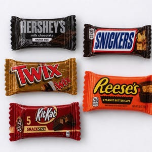 May include: Five individually wrapped snack-size chocolate bars arranged on a white surface. The collection includes a black Hershey's milk chocolate bar, a brown Snickers bar, a gold Twix bar, an orange Reese's peanut butter cups pack, and a red KitKat bar.